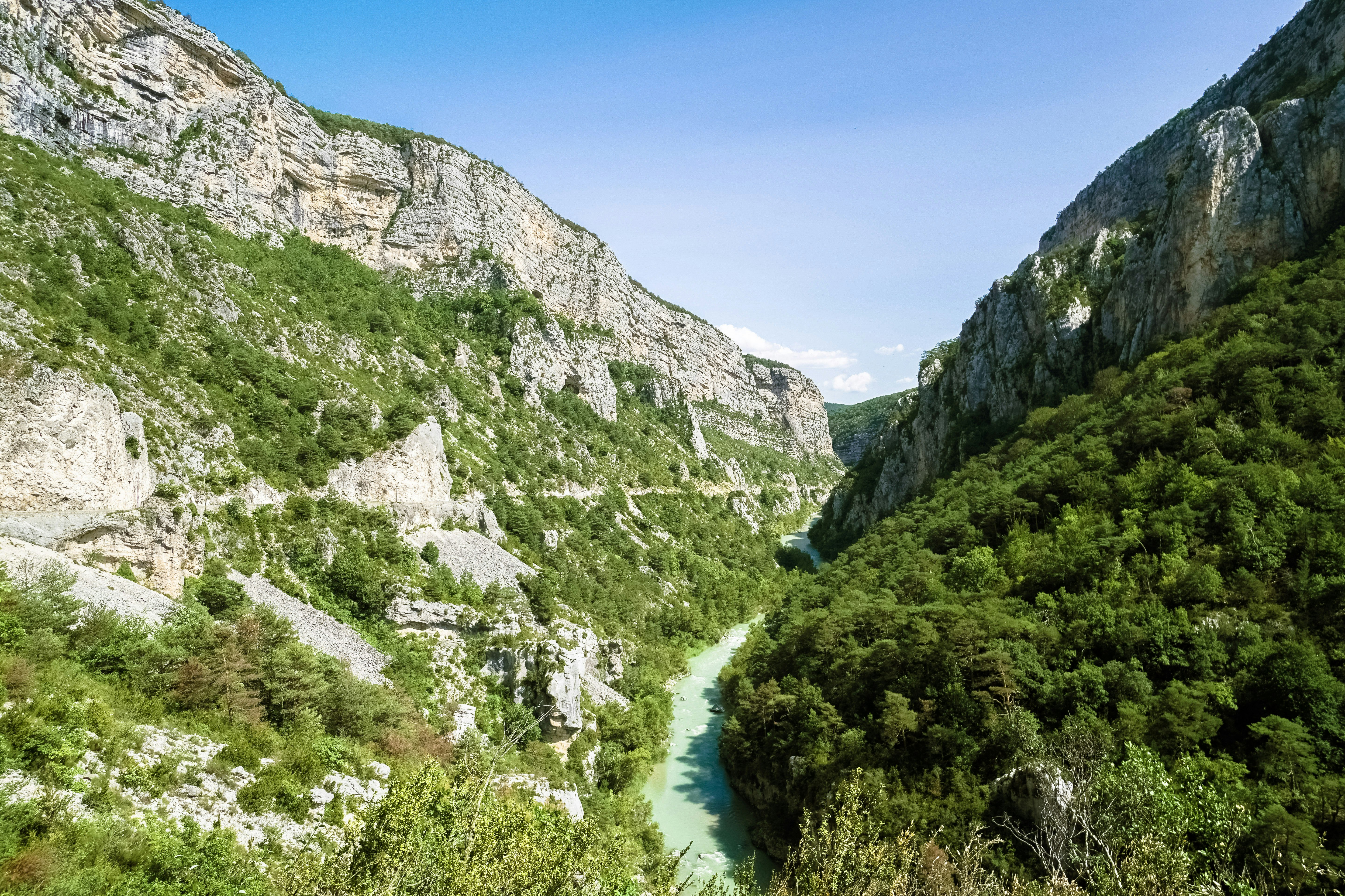 green and gray mountains beside river under blue sky during daytime